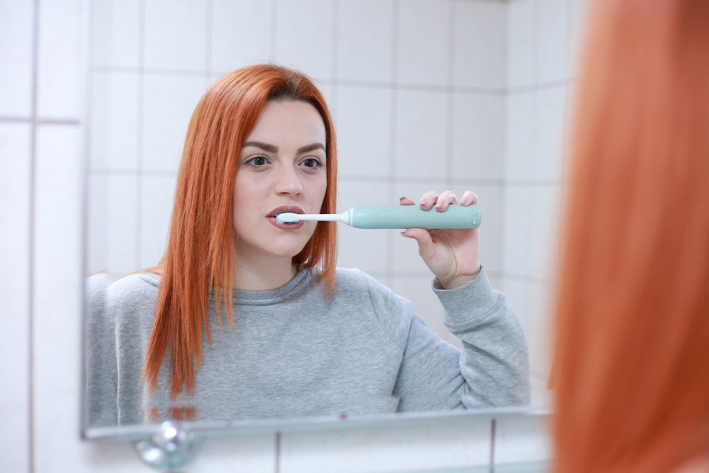 Brushing too hard can contribute to sensitive teeth.